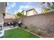 Outdoor patio features synthetic grass, brick pavers, grill, and seat with privacy wall at 25 Lone Cove Ct # 2, Henderson, NV 89012