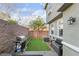 Outdoor patio features synthetic grass, brick pavers, grill, and seat with privacy wall at 25 Lone Cove Ct # 2, Henderson, NV 89012