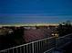 Evening scene captures tiled roofs with city lights twinkling in the distance, viewed from the backyard at 2536 Faiss Dr, Las Vegas, NV 89134