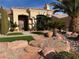 Welcoming front entrance featuring desert landscaping with decorative rocks, lush greenery, and a charming stone walkway at 2536 Faiss Dr, Las Vegas, NV 89134