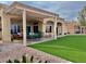 Covered outdoor patio with ample seating, manicured artificial turf, and desert landscaping for outdoor relaxation at 2536 Faiss Dr, Las Vegas, NV 89134