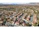 Expansive aerial view of a neighborhood with red-tiled roofs, lush greenery, and scenic mountain backdrop at 2637 Ohio Ct, Las Vegas, NV 89128