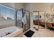 Well-lit bathroom showcasing a bathtub, glass-enclosed shower, and double sink vanity with ample counter space at 2637 Ohio Ct, Las Vegas, NV 89128
