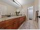 Bathroom featuring double sinks, granite countertops, and wood cabinets, along with decorative accents at 2637 Ohio Ct, Las Vegas, NV 89128