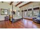 A large bedroom has a four-poster bed, hardwood floors, wood beam ceilings and many windows at 26425 Park St, Nelson, NV 89005
