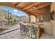 This outdoor kitchen features a bar, grill, ceiling fans and a beautiful desert view at 26425 Park St, Nelson, NV 89005