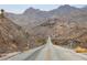 Straight road leading into a desert community with a mountain range view at 26425 Park St, Nelson, NV 89005
