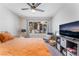 Well-lit bedroom featuring a ceiling fan, comfortable chair, and mounted TV at 3062 Tarpon Dr # 201, Las Vegas, NV 89120