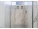 Modern shower featuring white marble tile walls, hexagon floor tiles and built-in shelving at 4411 Elk Point Cir, Las Vegas, NV 89147