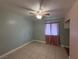 Bedroom with neutral walls, ceiling fan, tile flooring, and pink curtains, offering a cozy space at 5194 Saratoga Dr, Las Vegas, NV 89120