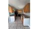 Well-lit kitchen featuring tile flooring, wood cabinetry, and granite countertops at 5194 Saratoga Dr, Las Vegas, NV 89120