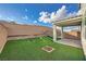 Landscaped backyard featuring brick walls, artificial turf and covered patio at 5399 El Nevero St, Las Vegas, NV 89166