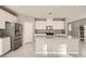 Well-lit kitchen boasts white cabinets, stainless appliances, and a functional center island at 5399 El Nevero St, Las Vegas, NV 89166