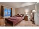 A calm bedroom featuring carpeted floors, a large window, and comfortable furnishings at 5416 Irish Spring St, Las Vegas, NV 89149