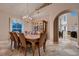 Dining room with a traditional chandelier, a view of the living area, and a built-in china cabinet for storage at 5416 Irish Spring St, Las Vegas, NV 89149
