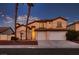 Two-story home featuring a two-car garage, front yard with palm trees, and a warm, inviting exterior paint color at 5416 Irish Spring St, Las Vegas, NV 89149