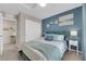 Comfortable bedroom featuring blue accent wall, white closet door and a cozy desk space at 56 Lomita Heights Dr, Las Vegas, NV 89138