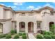 Charming townhome featuring a stucco facade, arched entry, and manicured landscaping at 56 Lomita Heights Dr, Las Vegas, NV 89138