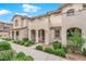Well-kept townhome featuring stucco exterior, arched entry, and tidy landscaping at 56 Lomita Heights Dr, Las Vegas, NV 89138