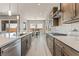 A modern kitchen with stainless steel appliances, light countertops, and a view to the dining area at 6312 Zephyr Peak Ct, Las Vegas, NV 89149