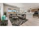 Bright, open-concept living room with a large sofa, contemporary decor, and an adjacent kitchen and dining area at 6312 Zephyr Peak Ct, Las Vegas, NV 89149