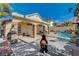 Inviting backyard with a refreshing pool, an outdoor fireplace, and a covered patio area, perfect for relaxation and entertaining at 6587 Lucky Boy Dr, Las Vegas, NV 89110