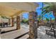 Outdoor patio with stone columns and seating, with a peek of the pool area in the backyard at 6587 Lucky Boy Dr, Las Vegas, NV 89110