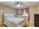 Bright bedroom with a ceiling fan, a mirror over a dresser, and a comfortable bed at 6587 Lucky Boy Dr, Las Vegas, NV 89110