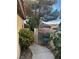 A view along the side of the home with lush landscaping along a walkway at 6587 Lucky Boy Dr, Las Vegas, NV 89110