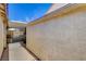 A view along the side of the home showing stucco and a covered area at 6587 Lucky Boy Dr, Las Vegas, NV 89110