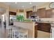 Modern kitchen with stainless steel appliances, dark wood cabinetry, breakfast bar, and granite countertops at 6587 Lucky Boy Dr, Las Vegas, NV 89110