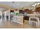Well-equipped kitchen with stainless steel appliances, dark wood cabinetry, breakfast bar, and tiled flooring at 6587 Lucky Boy Dr, Las Vegas, NV 89110