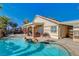 Stunning pool area with rock features and lush landscaping, creating a private backyard oasis at 6587 Lucky Boy Dr, Las Vegas, NV 89110