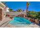 A relaxing backyard pool with surrounding rock accents and a playful slide for added fun at 6587 Lucky Boy Dr, Las Vegas, NV 89110