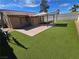 Large backyard featuring a concrete patio, artificial turf, and a gazebo at 7324 Saybrook Point Dr, Las Vegas, NV 89128