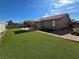 Large backyard with a sunshade, artifical turf, and paver trim at 7324 Saybrook Point Dr, Las Vegas, NV 89128