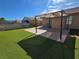 Spacious backyard with artificial turf, concrete patio, and sunshade at 7324 Saybrook Point Dr, Las Vegas, NV 89128