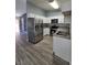 Modern kitchen featuring white cabinets, stainless steel appliances, and wood-look floors at 7324 Saybrook Point Dr, Las Vegas, NV 89128