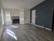 Open concept living room featuring a fireplace, wood-look floors, and natural light at 7324 Saybrook Point Dr, Las Vegas, NV 89128