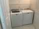 A bright laundry room features a white washer and dryer, with a wire shelf above for storage at 75 N Valle Verde Dr # 621, Henderson, NV 89074