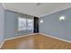 Serene bedroom with wood-look floors, a large window, and soft blue walls at 7713 Shore Haven Dr, Las Vegas, NV 89128