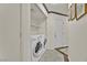 Neat laundry room with a modern washer and dryer, shelving, and a white door at 7713 Shore Haven Dr, Las Vegas, NV 89128