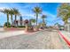 Gated community entrance with lush landscaping and mature palm trees against a bright blue sky at 8600 W Charleston Blvd # 2086, Las Vegas, NV 89117