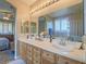 Bathroom featuring double sinks, white countertops, a large mirror, and framed cabinets at 9211 Wittig Ave, Las Vegas, NV 89149