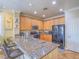 Kitchen showcasing granite counters, oak cabinets, and stainless appliances at 9211 Wittig Ave, Las Vegas, NV 89149