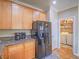 Spacious kitchen with wood cabinets, black appliances, and adjacent laundry area at 9211 Wittig Ave, Las Vegas, NV 89149
