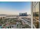 Expansive view features a resort pool, palm trees, the Las Vegas Strip, and a clear blue sky at 145 E Harmon Ave # 1202, Las Vegas, NV 89109