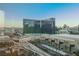 Urban landscape featuring a sleek building, overhead train, palm trees, and other architectural details at 145 E Harmon Ave # 1202, Las Vegas, NV 89109
