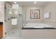 Features a walk-in glass shower and soaking tub with white tile surround and granite counter at 145 E Harmon Ave # 2603, Las Vegas, NV 89109