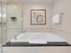 Close-up of a soaking tub with granite surround next to a clear glass walk-in shower at 145 E Harmon Ave # 2603, Las Vegas, NV 89109